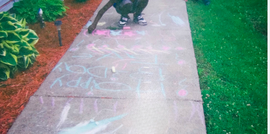 children drawing on the sidewalk with chalk